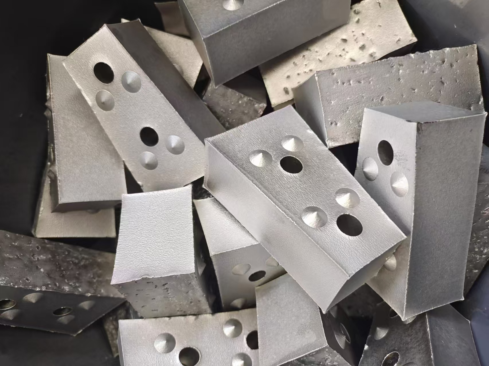 评估TM钢结合金质量需从材料性能、工艺控制及标准化测试等多维度展开：  一、性能定量分析 ‌强度与塑性平衡‌：通过拉伸试验测定屈服强度（≥380MPa）、抗拉强度（480-620MPa）及延伸率（≥24%），结合控轧控冷工艺（TM工艺）优化晶粒细化效果4。采用瞬时拉伸应变硬化指数（n值）评估材料均匀塑性变形能力，突破传统Hollomon关系限制。 ‌ 冲击韧性验证‌：通过夏比冲击试验测定合金工具钢的断裂韧性，钼、钴等元素形成的碳化物可提升晶间粘结强度，使其冲击吸收功达60J以上。  ‌TiC颗粒增强机制‌：利用显微硬度计与磨粒磨损试验机，验证TiC质量分数与耐磨性的正相关性。当TiC含量提升至0.5wt%时，耐磨性较传统材料提升50%以上。  ‌焊接结构疲劳测试‌：按照标准开展高周疲劳试验，模拟风电机组塔架焊接件的交变载荷工况，结合断裂力学分析预测临界裂纹扩展速率。  二、工艺控制与质量分级 合金元素精准调控‌：采用ICP光谱法监控铌（0.02-0.05wt%）、钛（0.1-0.2wt%）等微合金元素含量，确保析出强化与细晶强化协同作用。 ‌ 质量分级体系构建‌：参照系列标准，建立包括力性能、工艺稳定性、缺陷控制等指标的分级评价模型，实现产品等级划分（合格品/一等品/优等品）。  以上的方法，都可统化判定TM钢结合金的综合性能等级，为矿业破碎，能源装备选材提供量化依据。